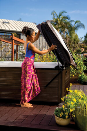 Femme ouvrant son spa à l'aide du lève couverture UpRite de Hot Spring